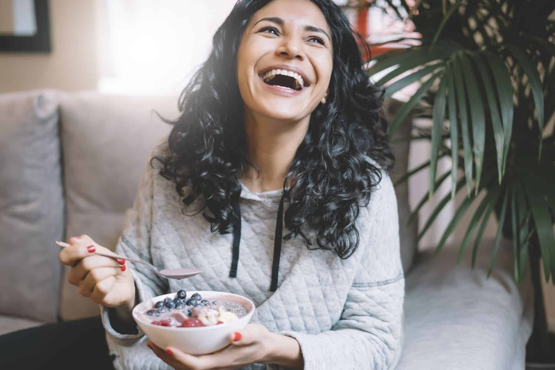 woman smiling eating healthy foods for a healthy gut microbiome